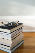 stack of books with a pair of glasses on top