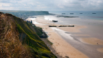 view of a beach from a mountain with military boats 