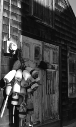 black and white photo of an old wooden building with a bunch of buoys hanging next to the doors