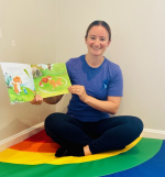 Woman sitting holding a children's book open