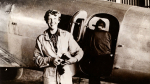 black and white photo of Amelia Earhart standing in front of a plane