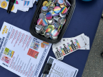 table with pride flag buttons, booklist and bookmarks