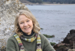 profile photo of a woman in front of a rock by the ocean