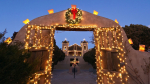 a rustic New Mexico archway decorated with string lights and a Christmas wreath