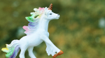 white unicorn toy with rainbow mane and tail