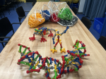 Bags of colorful toy construction pieces with a few model examples