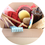 open cardboard box overflowing with household items.