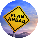 road sign reading PLAN AHEAD with background of sky and mountains.