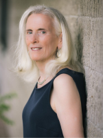 author Merrie H. Reagan standing in profile with head turned toward camera, wearing black sleeveless
