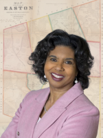 headshot of local author Lisa Braxton, standing with arms crossed in pink blazer