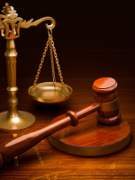 a wooden gavel sitting in front of gold scales