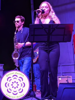 female singer & male saxophone player on stage mid-show