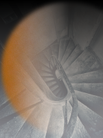 black & white spiral staircase looking down, overlaid with hazy red layer