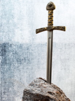 A sparkling silver sword is wedged and stuck inside a stone.