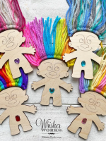 Woodcut trolls with rainbow-colored yarn for hair and a gemstone on each of their bellies.