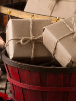 red basket holding brown-paper-and-twine wrapped boxes
