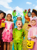 A group of children in various Halloween costumes smiling for the camera.