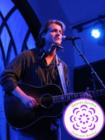 musician Matt Borrello performing at mic with guitar