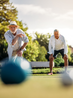 two men playing bocce, with balls in foreground and men in focus in background