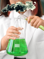 A child holding a test tube with green liquid in it and a small gray cloud above the test tube and i