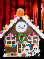 A spooky gingerbread house with candy ghosts on an orange black forst background.