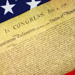 The Declaration of Independence with the US flag in the background.