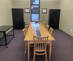 Room with a table and chairs for meetings or study.