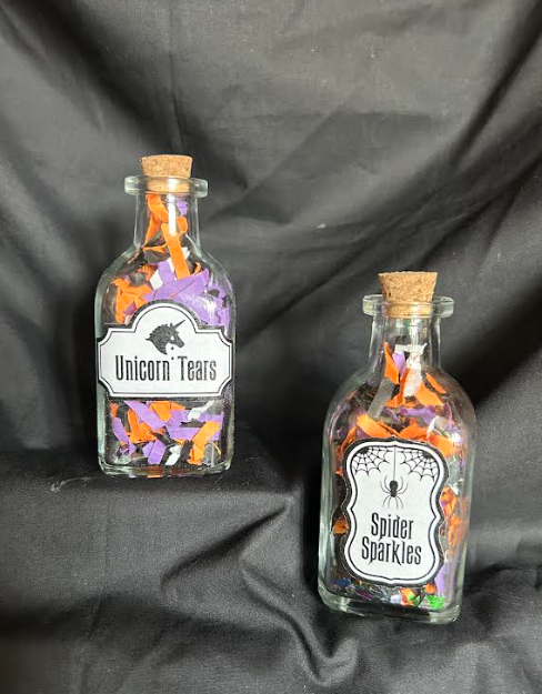 Two glass bottles with colorful paper confetti unicorn tears