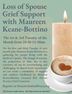 A candle sits next to a cup of coffee.