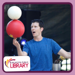 Juggler Bryson Lang balances two basketball-sized balls on top of one another in one hand