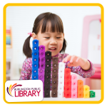a child uses math blocks to build a pattern. the child is in a classroom setting.