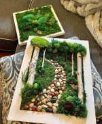 Frame with moss, twigs and rocks designed to look like a forest scene