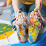 A photo of a child's feet covered in paint