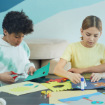 Two teens cutting and decorating with paper