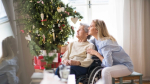 Image of two women, one old, one younger, looking at a Christmas tree 