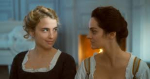 image of two women, one blonde, one brunette, staring at each other