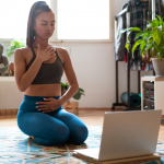 woman meditating in front of laptop