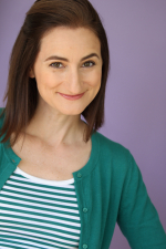 Smiling actress in a green cardigan.
