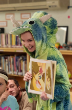Woman in dinosaur costume holding book