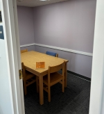image of small carpeted meeting room with 4 chairs,  table