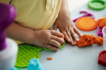Kids hands playing with playdough.