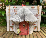 white background with dark cream graphic print featuring a photo of a folded book fairy house craft