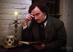 Edgar Allen Poe impersonator with a skull on a desk.