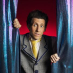 andrew peeking around stage curtain