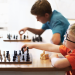 Two boys playing games of chess