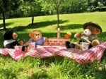picture of teddy bears eating on a picnic blanket