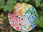 Round stepping stone with a rainbow of colored glass rounds. 