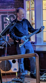 Randy Austill playing guitar in a dark lit venue