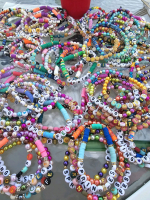 Pile of beaded friendship bracelets featuring various sayings