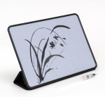 A black, tablet-like device that sits propped up, with a light gray surface. A flower is painted wit